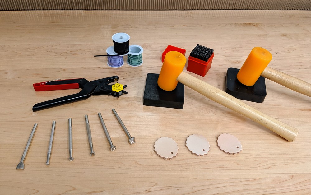 photo of tools used to work with leather projects, including mallets, leather stamps, and stamping pads.